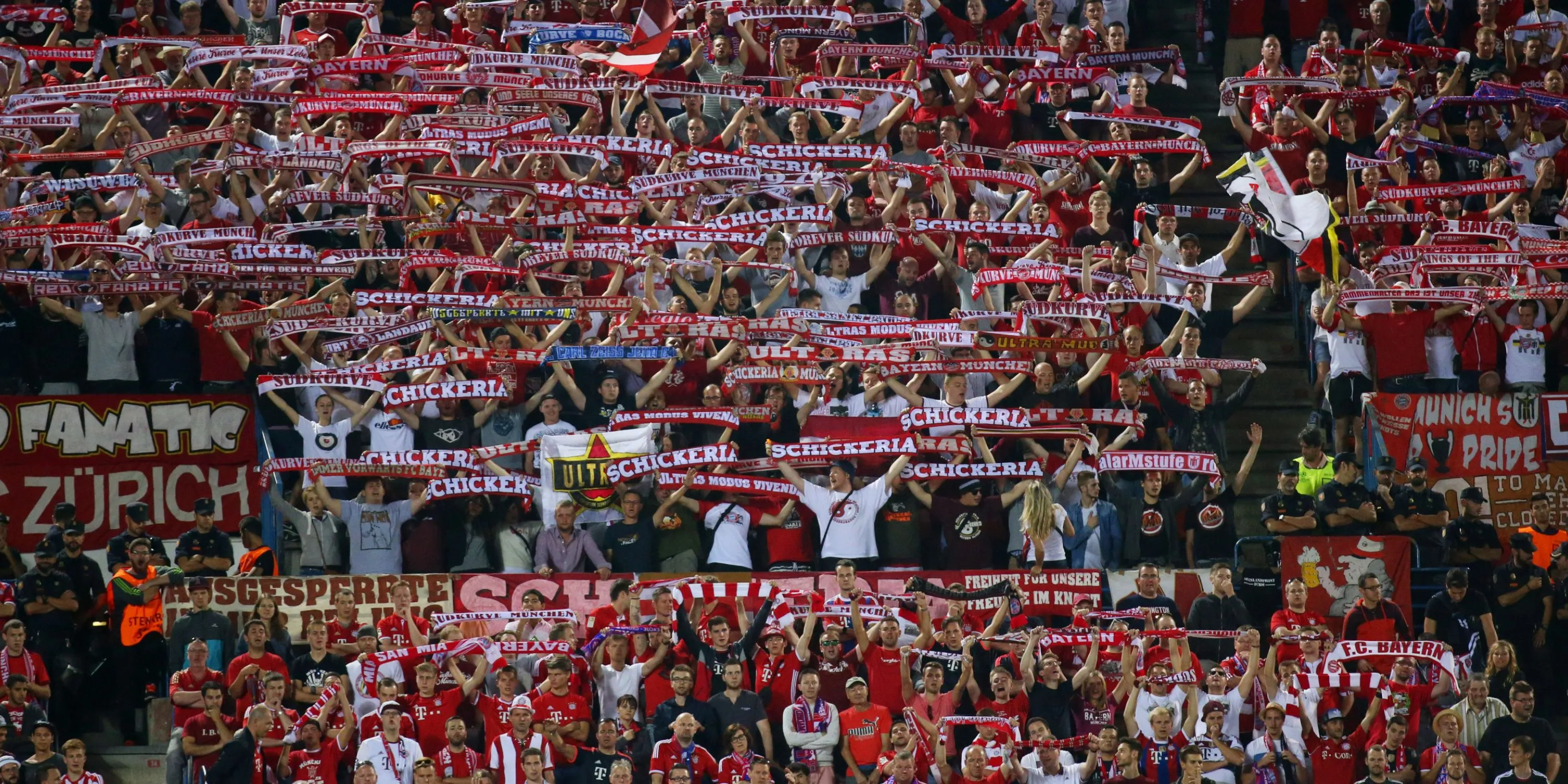 Cổ động viên Bayern Munich giơ cao khăn quàng cổ và hát vang