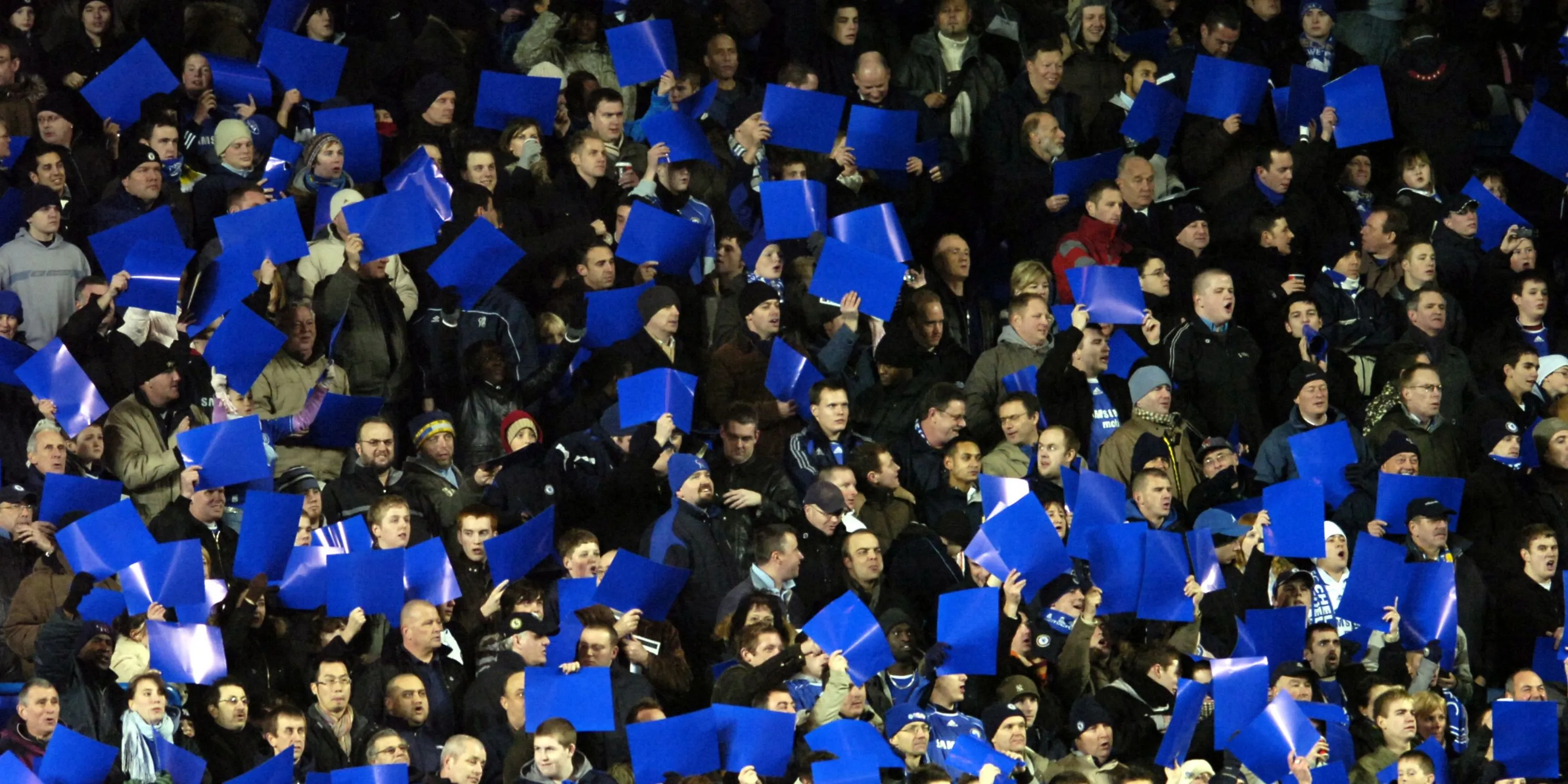 Cổ động viên Chelsea giơ cao biểu ngữ màu xanh tại Stamford Bridge