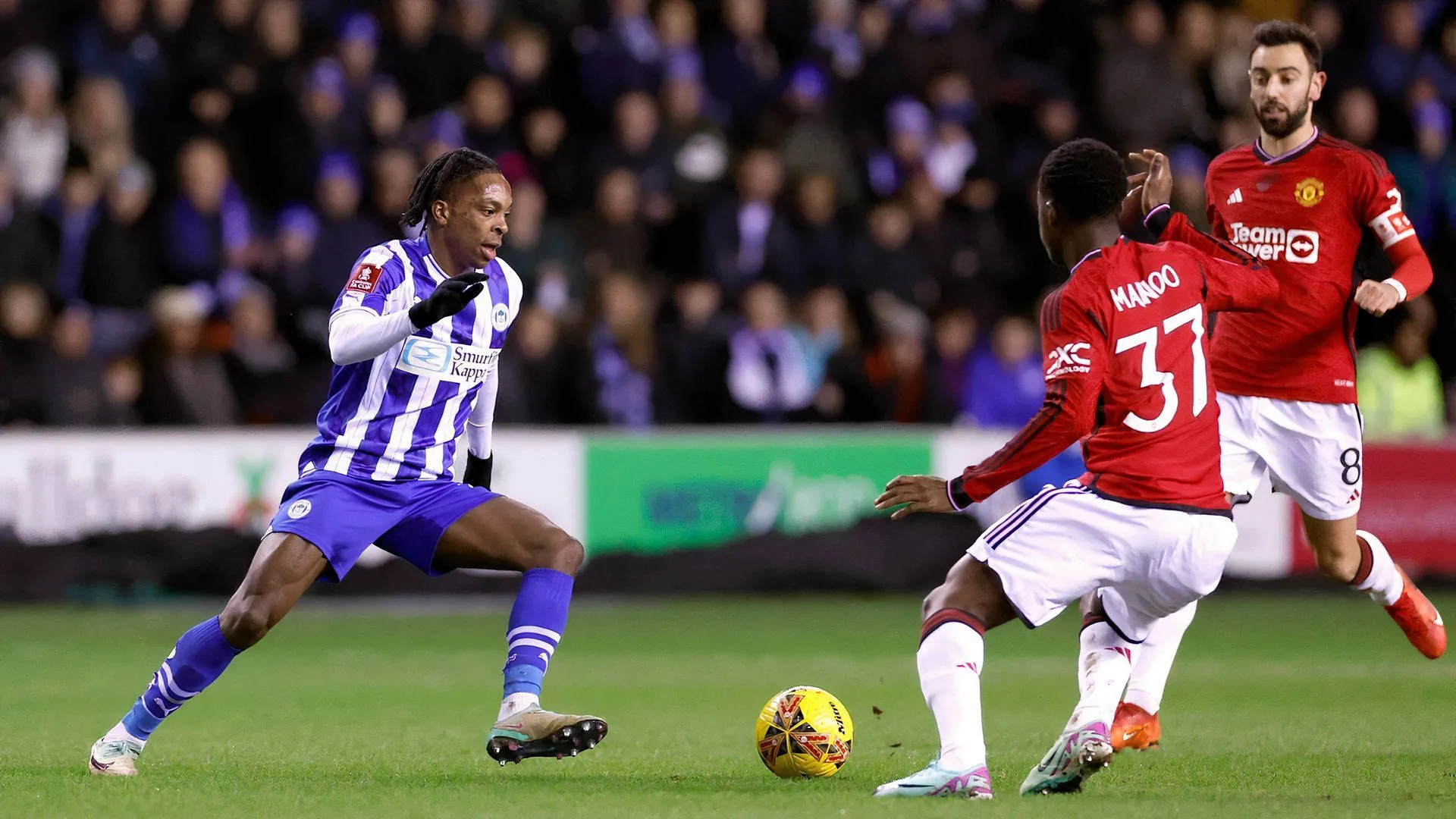 Tiền vệ Martial Godo trong màu áo Wigan Athletic đối đầu Manchester United